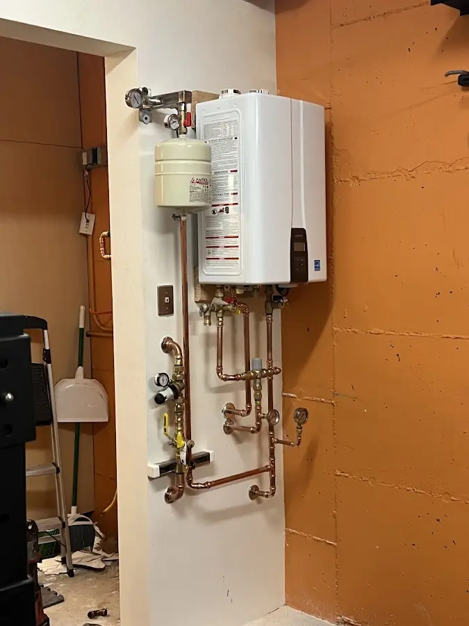 Plumbing technician inspecting water heater connections in Harris